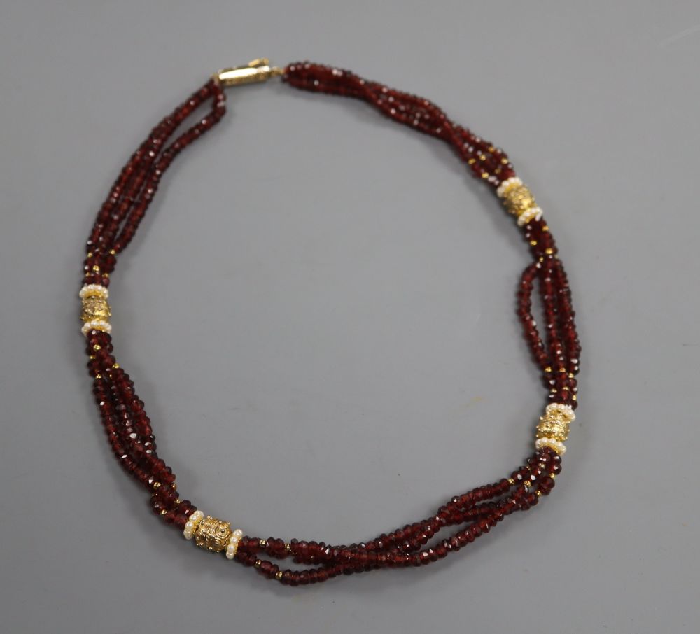 A modern gilt metal mounted and rough cut garnet bead triple strand necklace, 47cm.